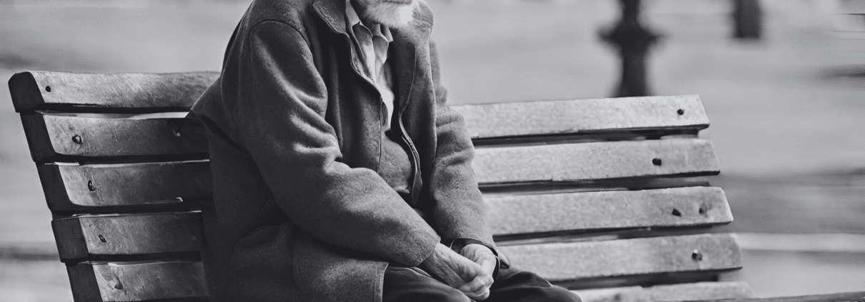 old man sitting alone in a bench with heads down